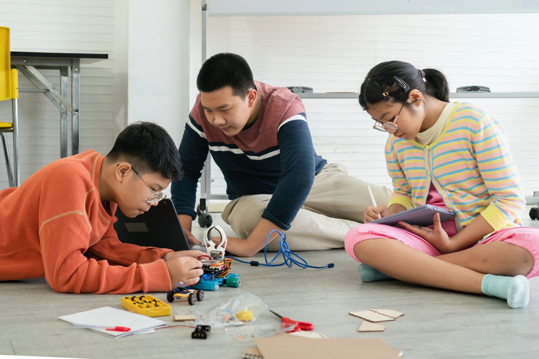 Students learning robotics technology together in a classroom